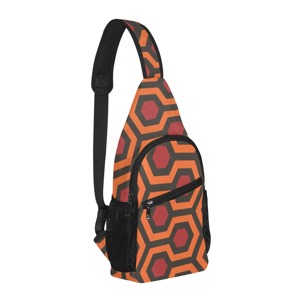 Opposite three-quarter view of chest bag with burnt-orange and red Haunted Hotel geometric print and shoulder strap
