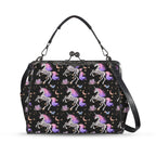 Kisslock crossbody bag with skeleton unicorns with purple and pink manes on black, front view with handle and shoulder strap