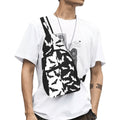 Model wearing crossbody chest bag with black and white bat pattern