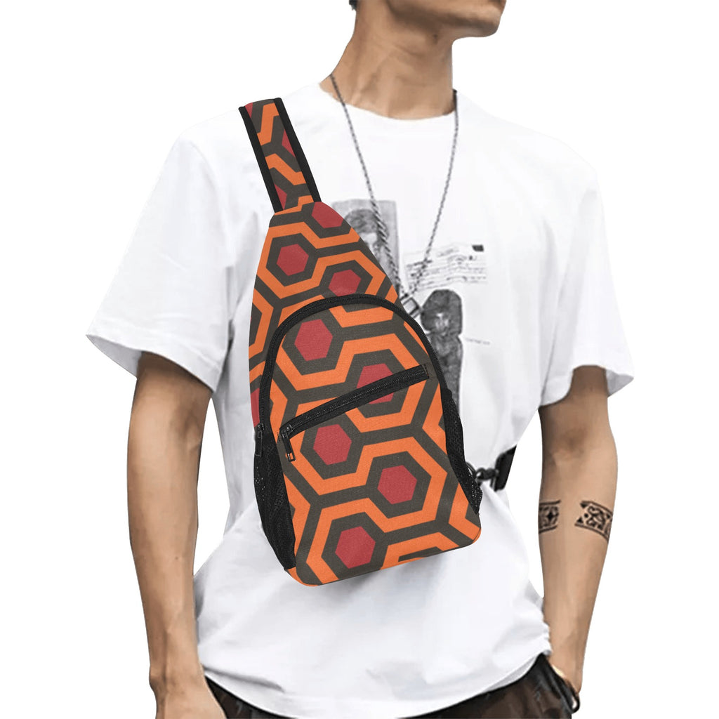 Model wearing crossbody chest bag with burnt-orange and red Haunted Hotel geometric print