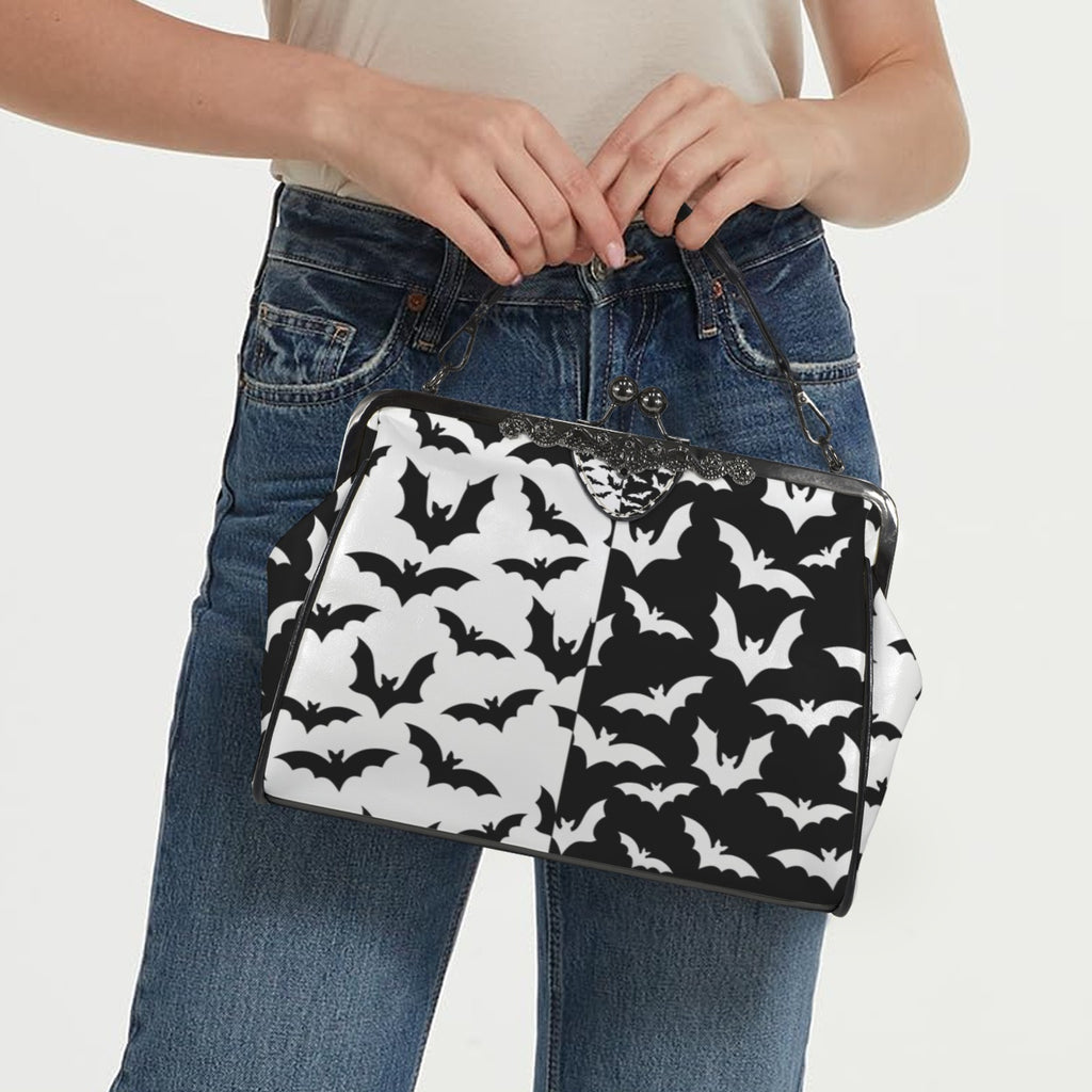 Model carrying kisslock bag with black and white bat pattern by the top handle