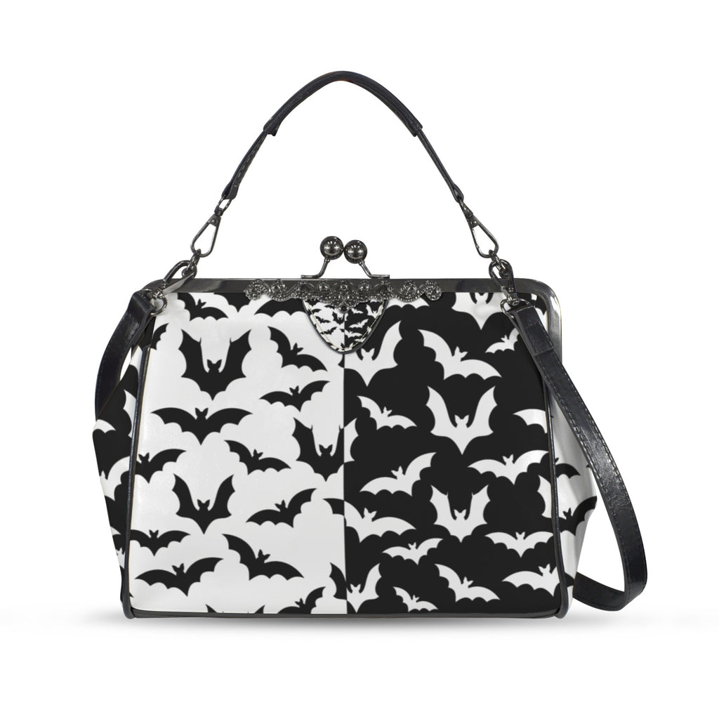 Kisslock crossbody bag with black and white bat pattern, front view with handle and shoulder strap
