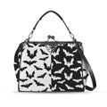 Kisslock crossbody bag with black and white bat pattern, front view with handle and shoulder strap