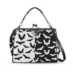 Kisslock crossbody bag with black and white bat pattern, front view with handle and shoulder strap