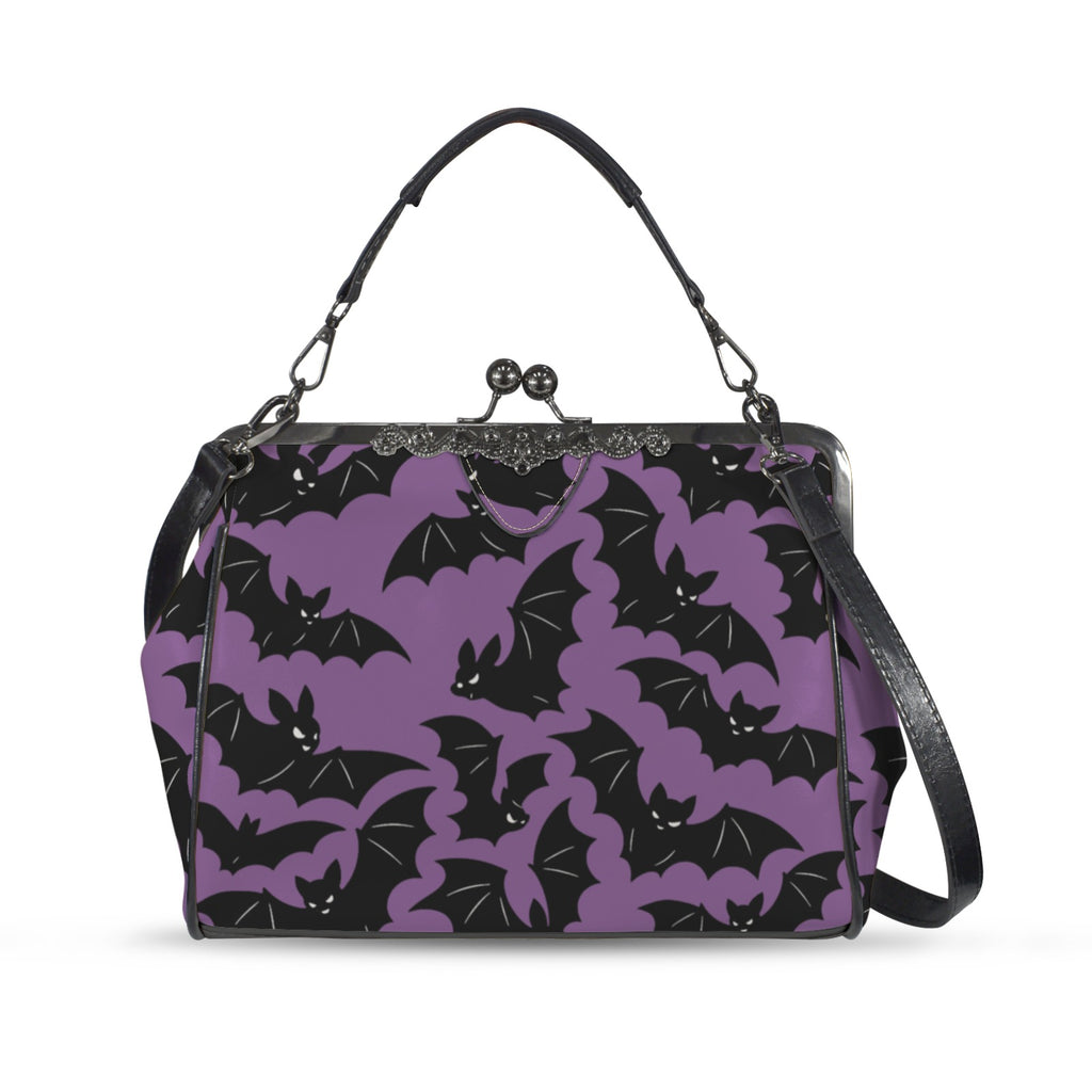 Kisslock crossbody bag with purple and black bat pattern, front view with handle and shoulder strap