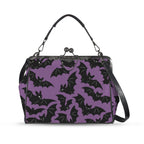 Kisslock crossbody bag with purple and black bat pattern, front view with handle and shoulder strap