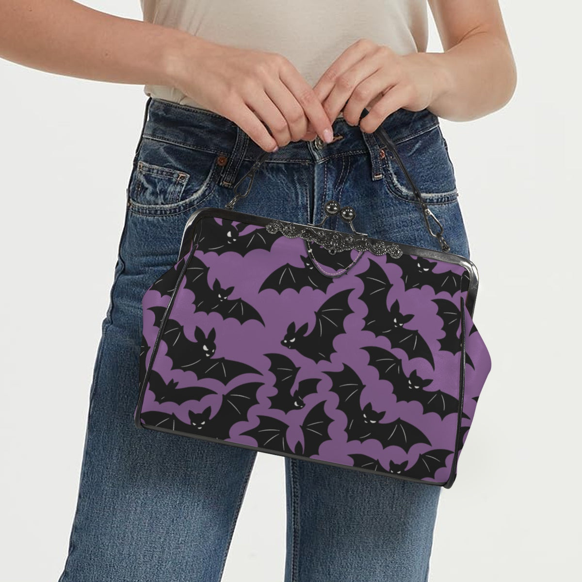 Model carrying kisslock bag with purple and black bat pattern by the top handle